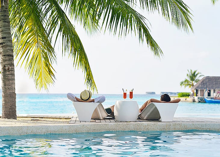 A married couple enjoying their vacation by a beautiful island beach.