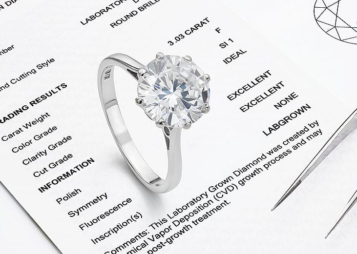 A ring with lab-grown diamond on top of a lab-grown diamond report.