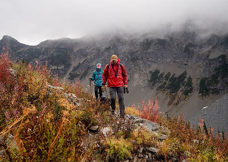 Hikers cross a meadow on a hike near Stiletto Peak lookout in the North Cascades in Washington, near the Methow Valley.