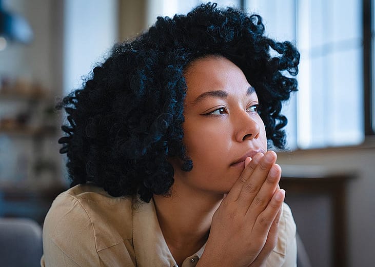 A pensive young woman looking into the distance.
