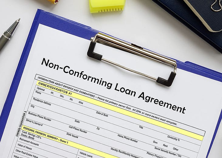 A non-conforming loan agreement document on a clipboard.