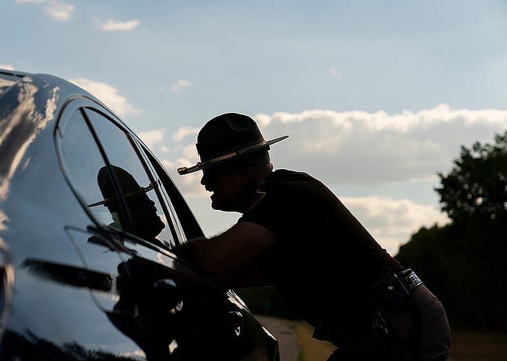 An OHP trooper talks with a driver that was pulled over for speeding during a joint operation between OHP and ICE in Pittsburg County, Oklahoma on September 3, 2026.