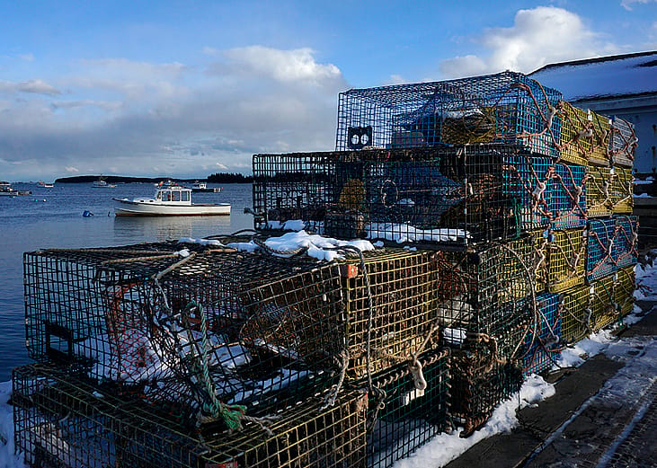 Snow covered lobster traps sit on a dock in Jonesport, Maine.