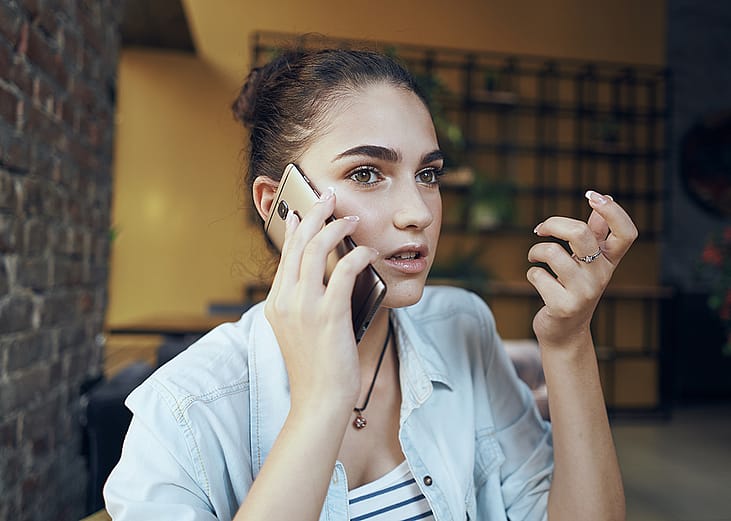 A student talking to a loan servicer over the phone about her loan repayment.