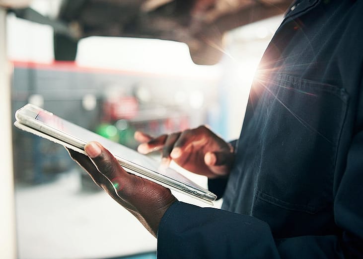 A mechanic looking at a checklist for inspection.
