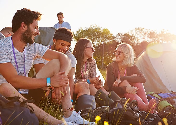 A group of friends relaxing outdoors during a camping holiday.