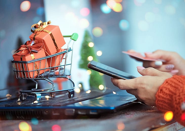 A person using a credit card as a payment option for her holiday shopping online.