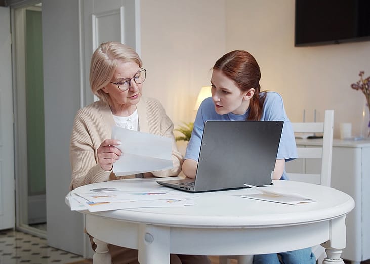 A senior mother reviewing documents together with her adult daughter.