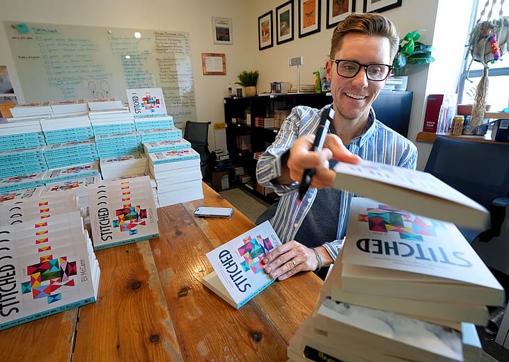 Salt Lake Tribune humor columnist Eli McCann signs copies of his new book called "Stitched" with Torrey House Press on Wednesday, Aug. 19, 2026.
