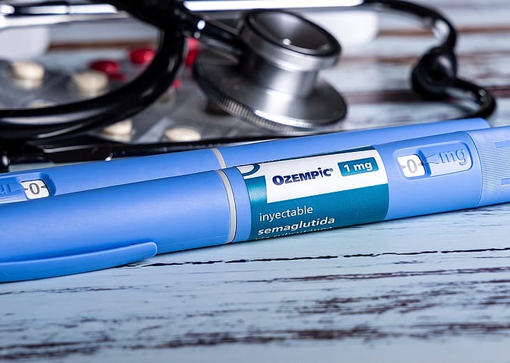 Ozempic semaglutide GLP-1 injection pens seem next to medicine pills and a stethoscope.
