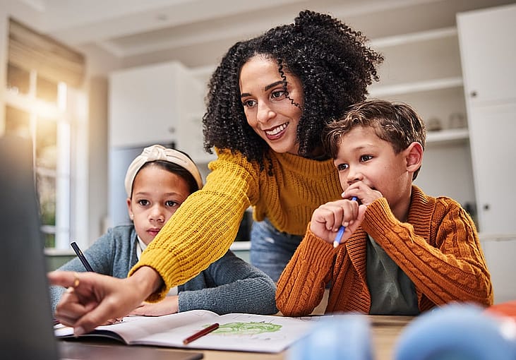 A parent teaching and helping her children on their school works at home.