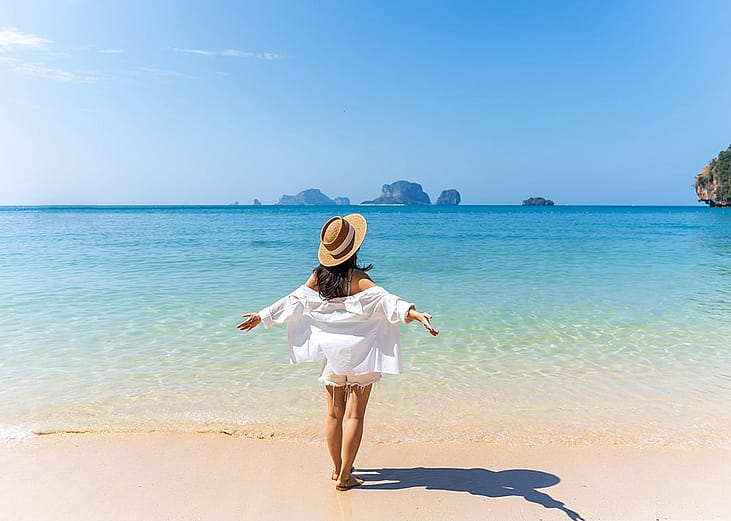 A person enjoying the beautiful white sand beach on a sunny day during a vacation.