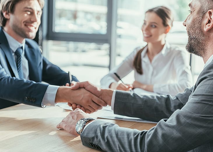 Business heads shaking hands after an agreement for faster capital access and loan qualifications for their companies.