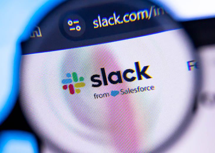 A macro view of Slack, a digital communication software, through a magnifying glass.