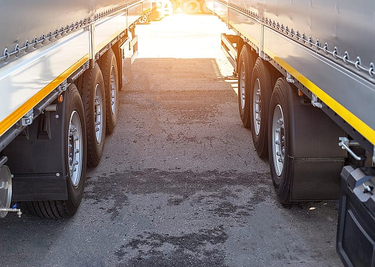 Cargo semi-trailer trucks parked in a truck stop.
