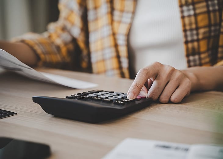 A person using a calculator to review tax-related payments for the whole year.