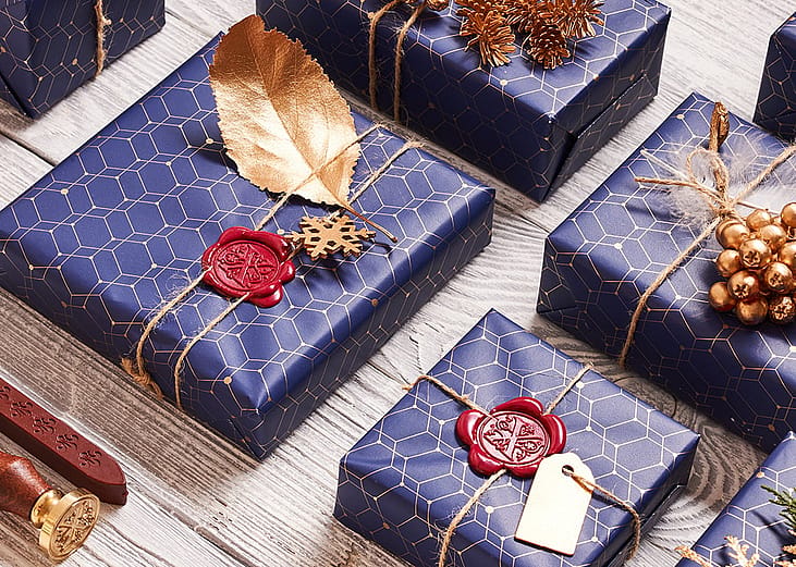 A flatlay of creatively wrapped and decorated holiday boxes arranged in a surface.