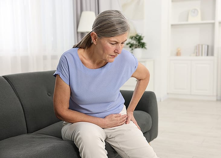 An elderly person experiencing a hip joint pain at home.