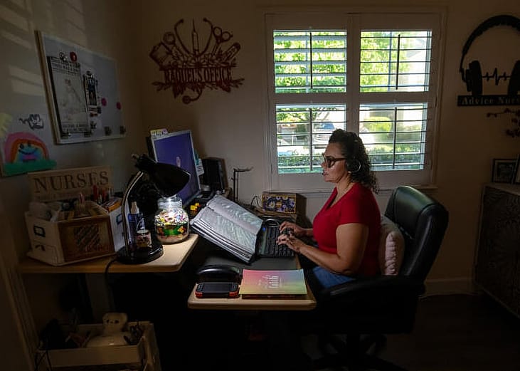 A nurse looking very focused by working from her home office.