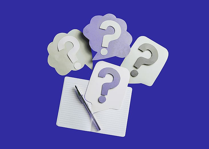 A custom illustration showing an open lined notebook with a pen and thought bubbles with question marks to depict curiosity.