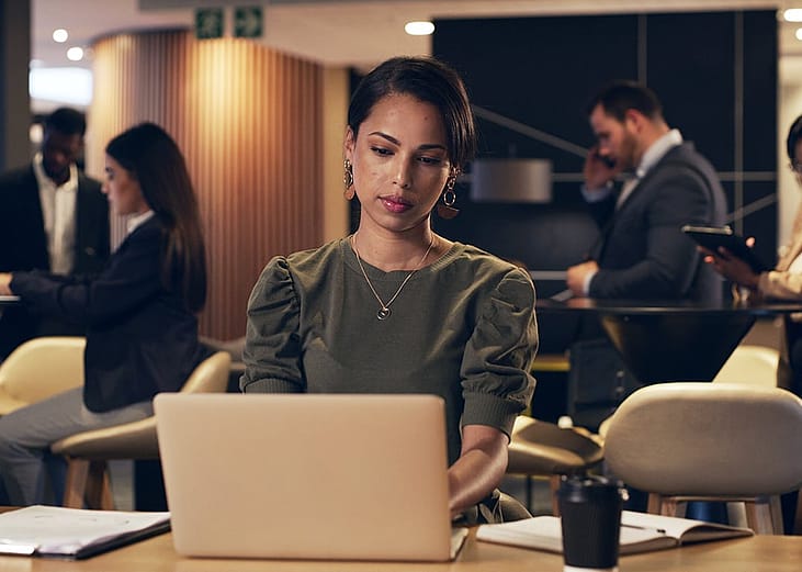 A businesswoman busily doing research on a laptop.