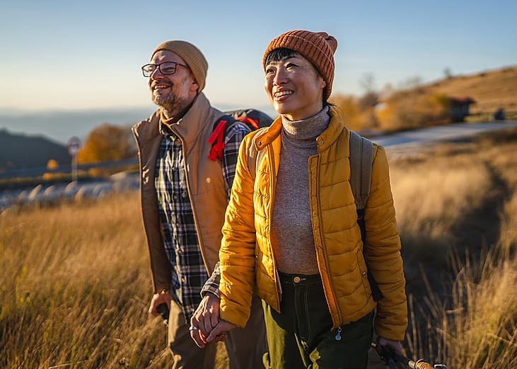 A middle-aged couple hiking outdoors during fall season.