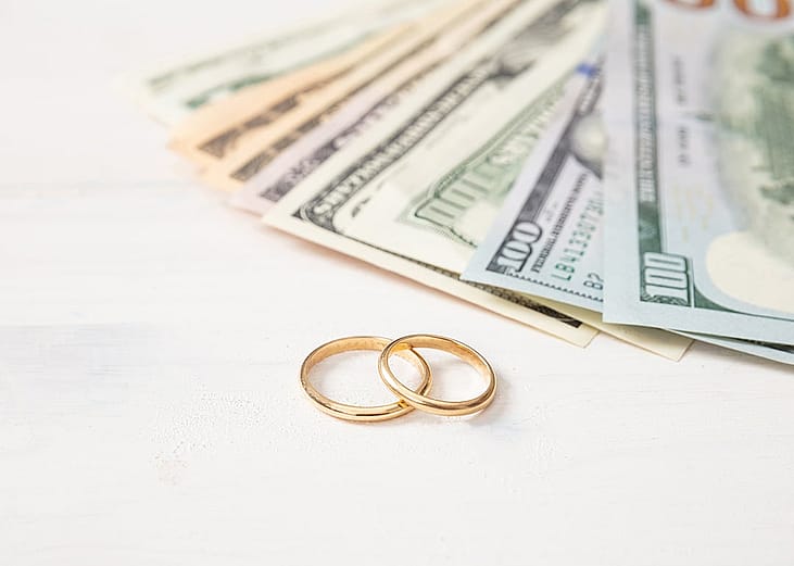 Wedding rings and cash as a concept of marriage planning.