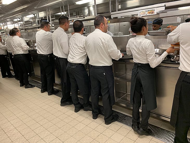 Cruise ship waiters standing in a galley.