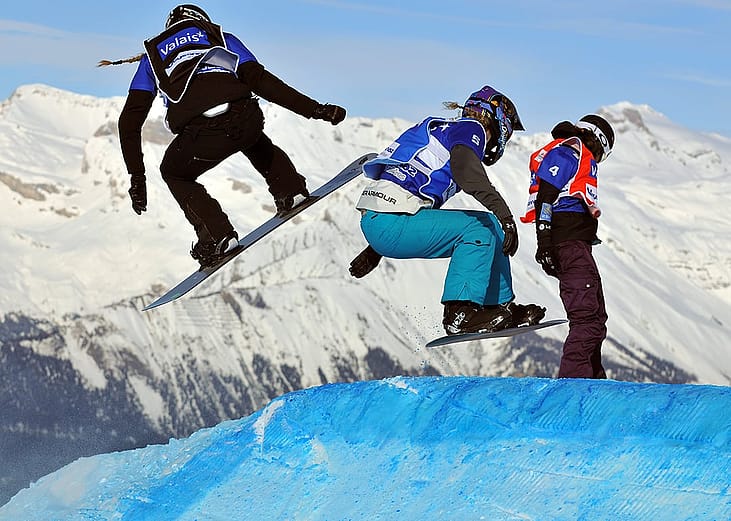 A group of snowboarding athletes in action.