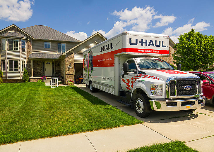 A U-Haul truck parked in front of a residential house.