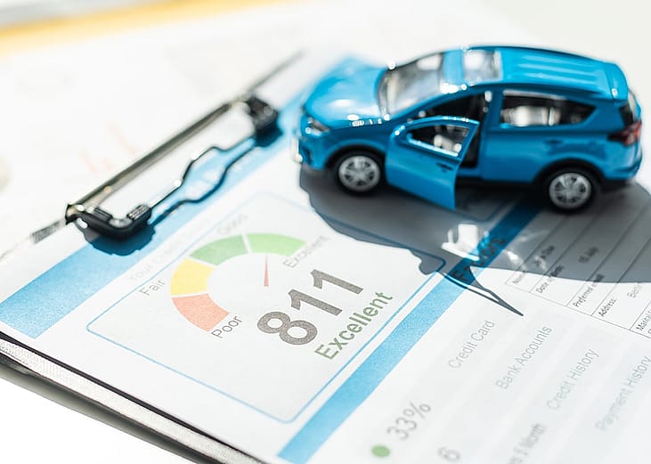 A model car placed above a credit banking score report.