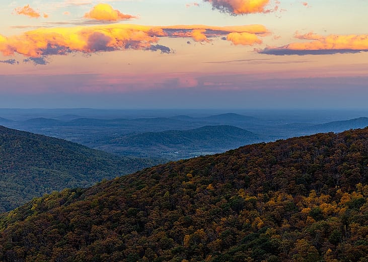 The Shenandoah National Park with lush forests and hills under the sunset sky during the fall in Virginia, USA.