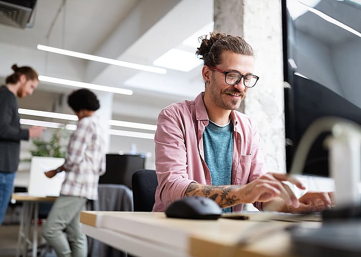 A male employee happily working in an office.