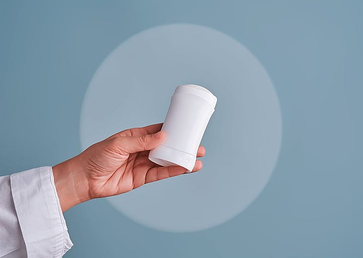 A hand holding a deodorant stick.