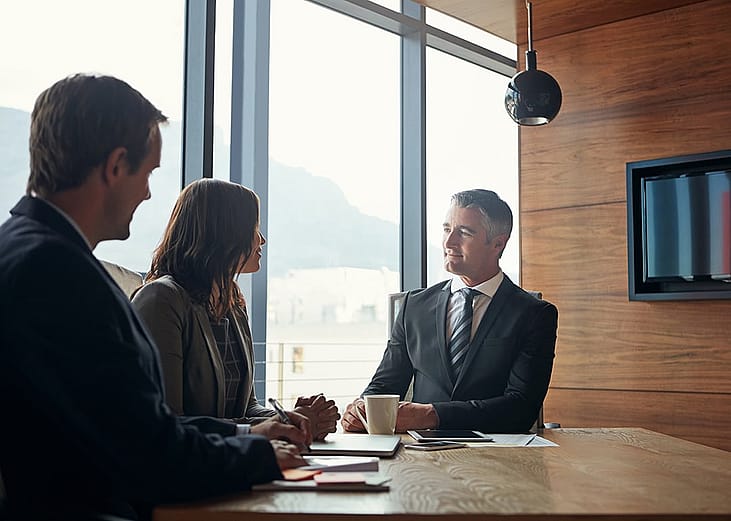 A tax team discussing their client's tax inheritance and acquisition plans in the office.