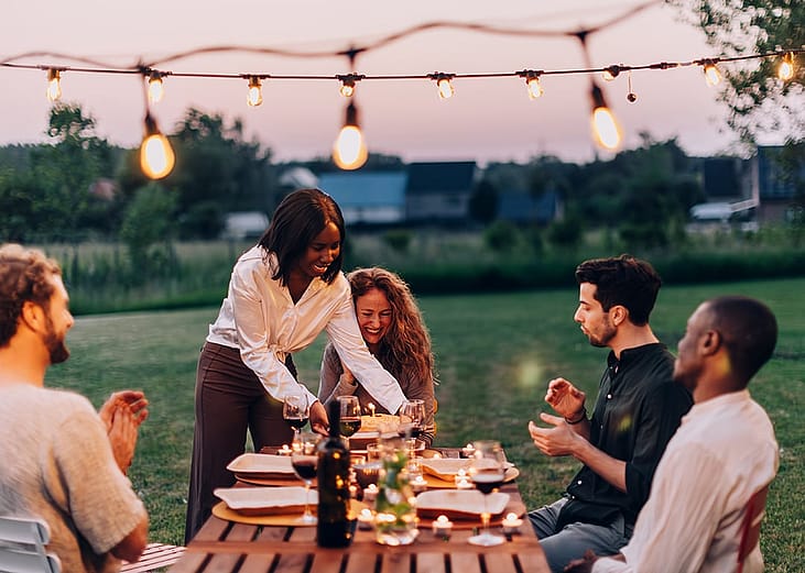 A group of friends having a joyful dinner outdoors.