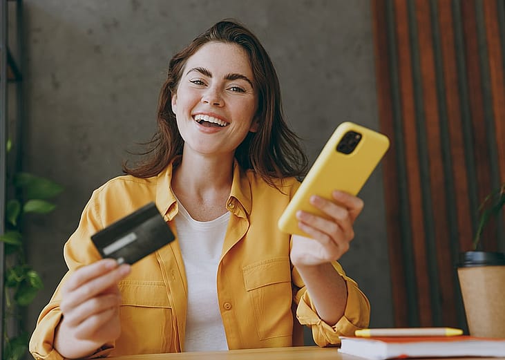 A happy woman purchasing online with credit card.