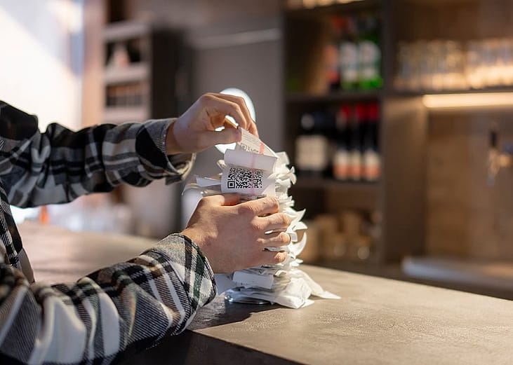 A waiter organizing a stack of order receipts after the lunchtime rush in the restaurant.