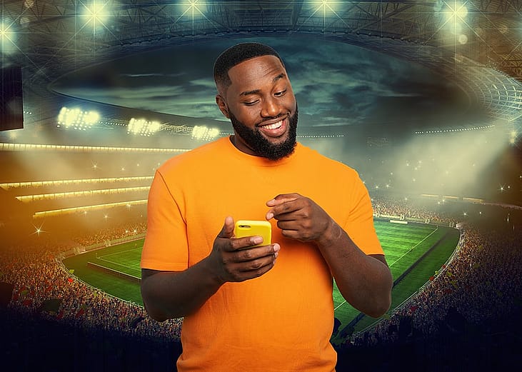 A person betting on a football match online while watching a live event on a smartphone.