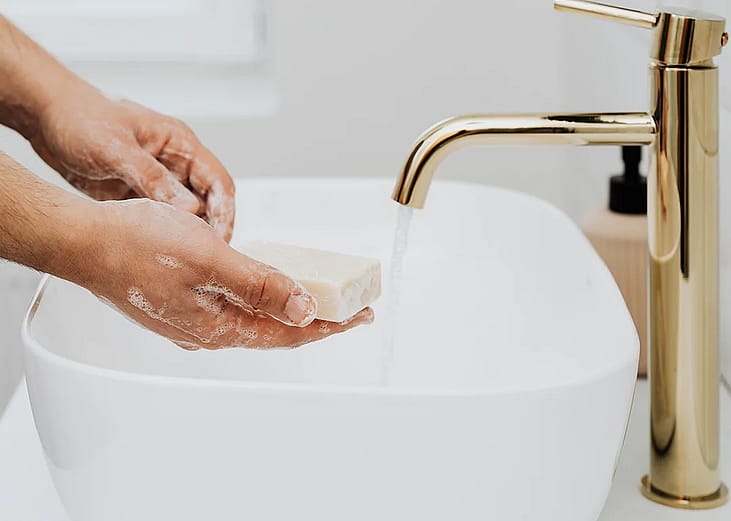 Man using a bar soap to wash his hands.