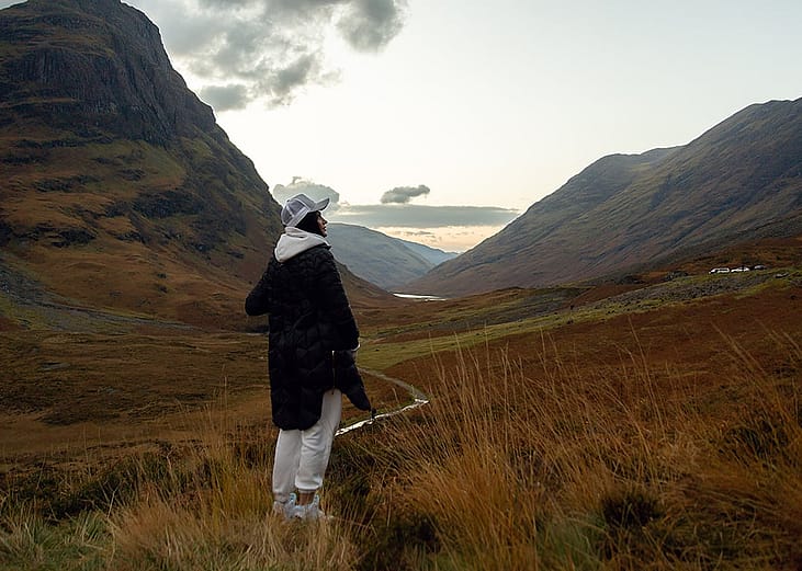 A woman enjoying the view of the majestic Scottish highlands.