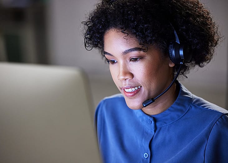 A professional woman working in a customer support or call center setting.
