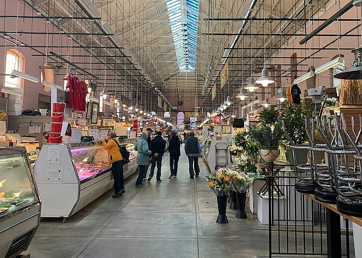 A local neighborhood's customers make retail purchase from butchers inside Eastern Market in Washington, DC.