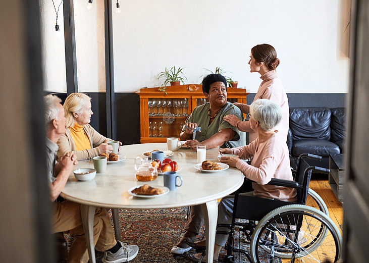 A group of older people at a table having breakfast.