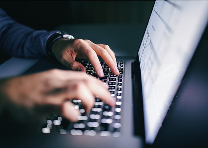 Hands typing on laptop