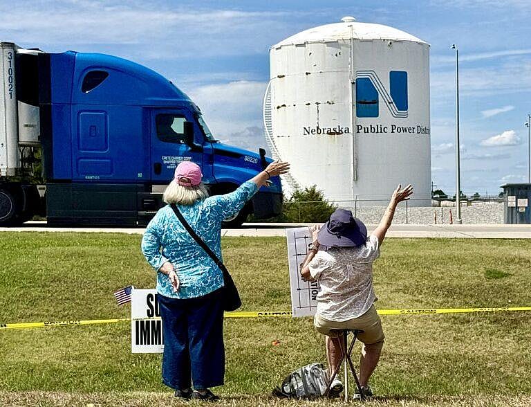 Demonstrators at the McCook immigration rally wave to traffic passing by on U.S. Highway 83.