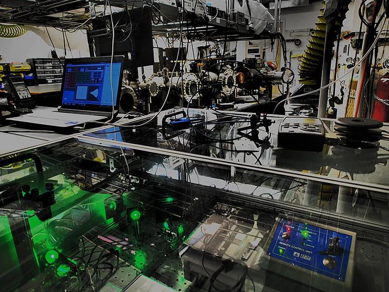 Stephen Leone’s lab full of equipment like vacuum chambers, vibration-suppression tables, lenses and crystal elements that shift, split and recombine laser beams, compress or expand light pulses and impart tiny delays into when pulses reach samples and detectors.