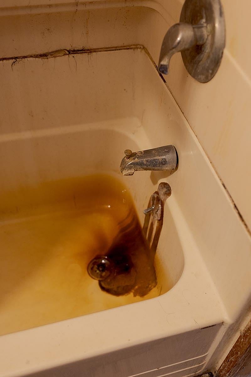 Discolored water emerges from the faucet in the shared bathroom of a family of farm workers, which they say stains both their skin and clothing yellow after showers and laundry.