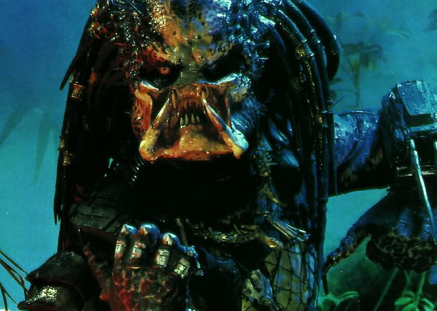 A slimy alien with big teeth and sharp metal gear.
