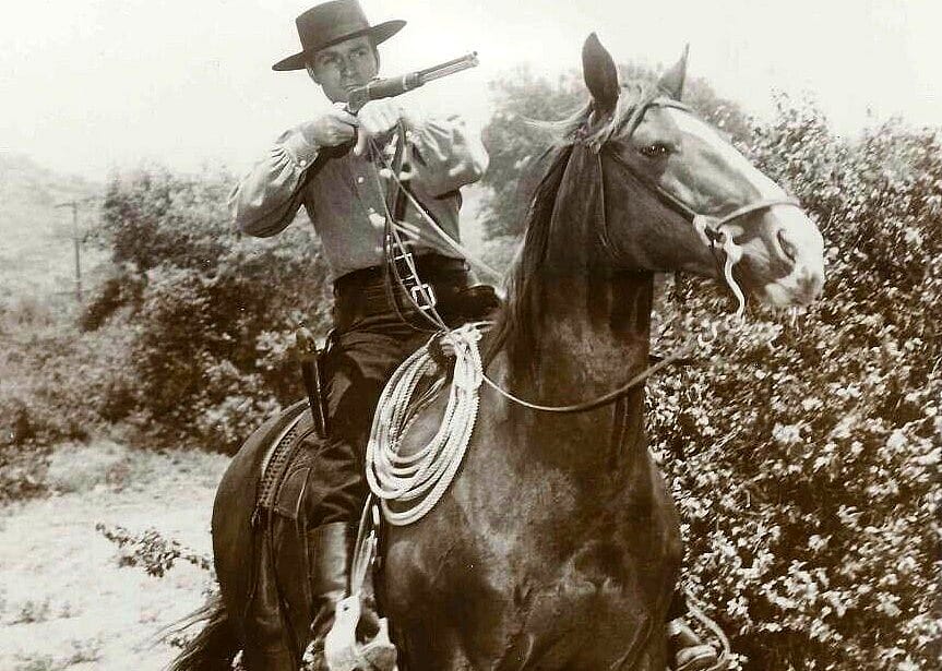 A man with a long gun on horseback.